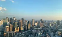 Daytime view of the Tokyo skyline with modern skyscrapers under a clear sky.