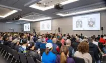 A room full of runners facing three screens on the wall as Sports Tours International staff present a pre marathon race briefing.