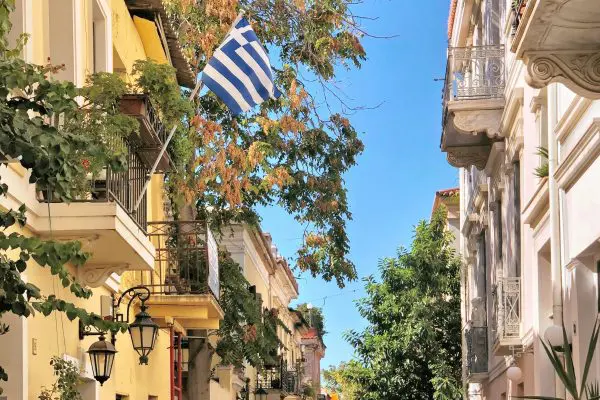 Narrow street with brightly coloured buildings and plats hanging from the walls