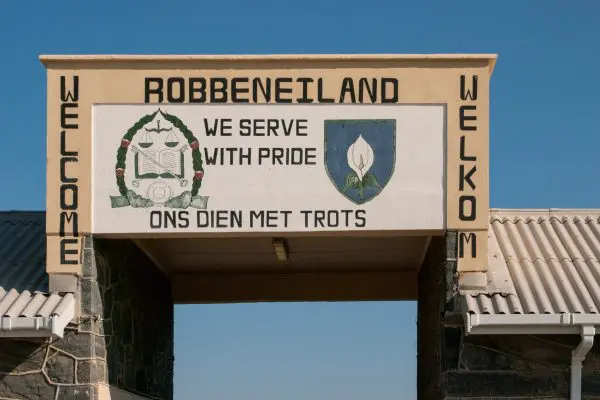 A sign showing the entrance to Robben Island Prison in Cape Town, South Africa, known for its historical significance as a former political prison.