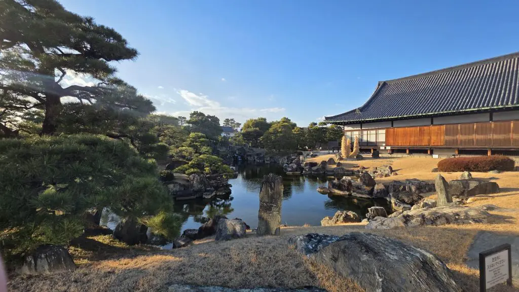 Traditional Japanese architecture sat on a lake in Kyoto, surrounded by lush foliage