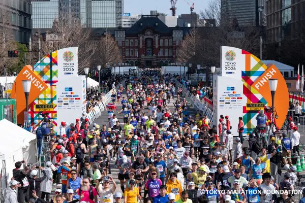 A large group of runners crossing the finish line at the Tokyo Marathon